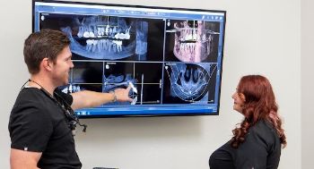 Dentist and team member looking at a patient's x-rays